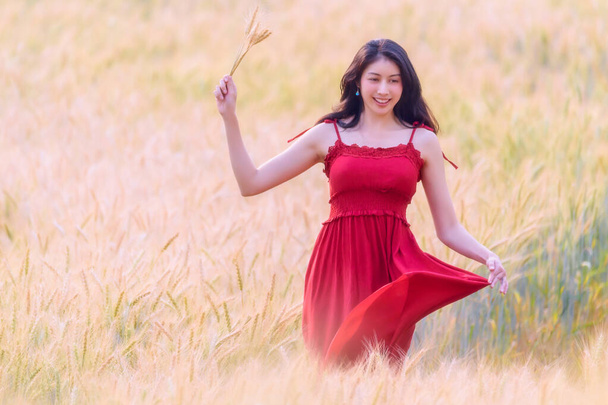 Hermosa chica disfrutando de la naturaleza en el campo de trigo a la luz del atardecer. Mujer feliz libre
 - Foto, imagen