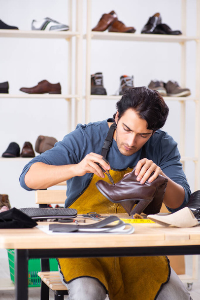Fiatal férfi cipő műhelyben javítása - Fotó, kép
