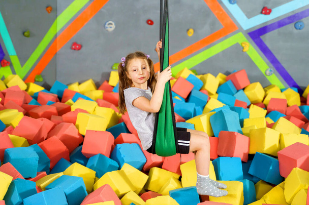 Children playing with soft cubes in the dry pool in play center. playground with foam blocks in trampoline club - Foto, Imagem