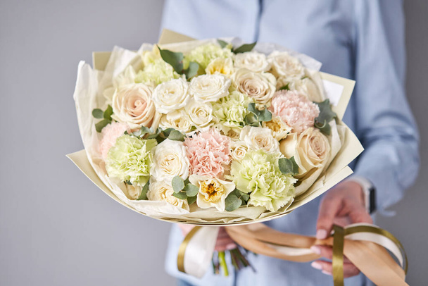 European floral shop. Beautiful bouquet of mixed flowers in woman hands. Work of the florist at a flower shop. Delivery fresh cut flower. - Fotoğraf, Görsel