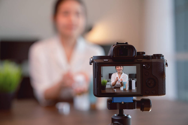Молода жінка з Азії, блогер відео онлайн, показує косметичні продукти і живе відео на цифровій камері. - Фото, зображення