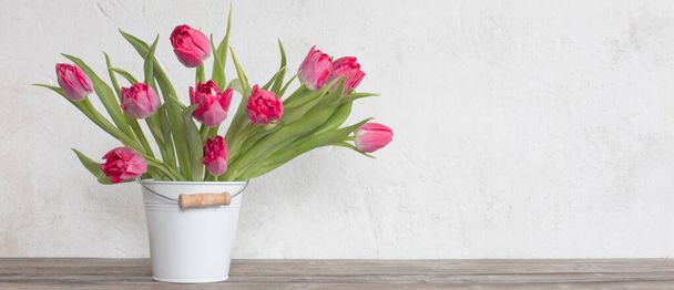 red tulips in bucket on background  old  white wall - Photo, Image