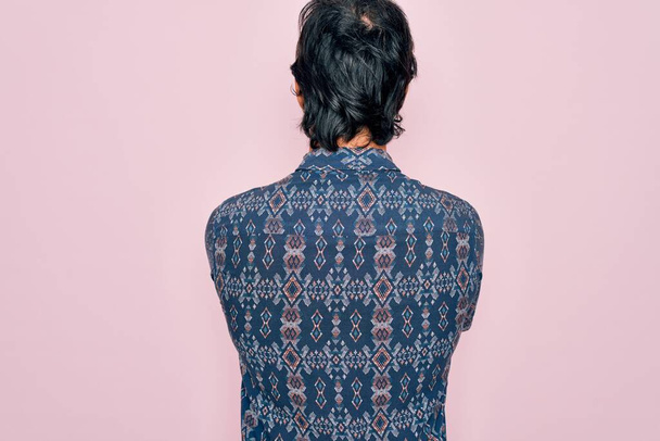 Young handsome hispanic bohemian man wearing hippie style over pink background standing backwards looking away with crossed arms - Foto, afbeelding
