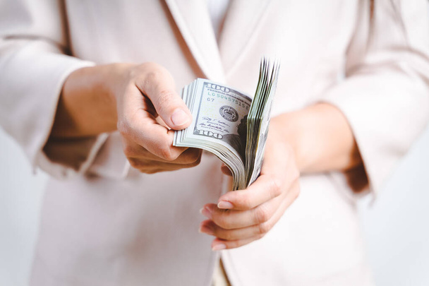 Primer plano de la mujer de negocios manos contando dinero billetes de dólar sobre fondo blanco. Concepto de dinero
. - Foto, imagen