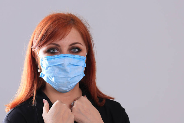 Muotokuva punatukkainen tyttö musta sininen lääketieteellinen naamio harmaalla pohjalla
 - Valokuva, kuva