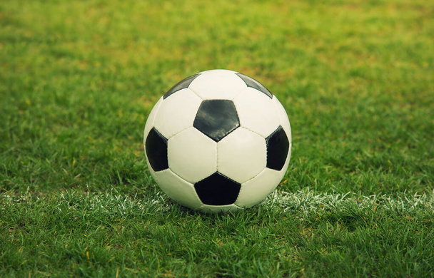 Bola de futebol clássico, padrão típico hexágono preto e branco, colocado no relvado do estádio. Bola de futebol tradicional no campo de grama verde da arena
. - Foto, Imagem