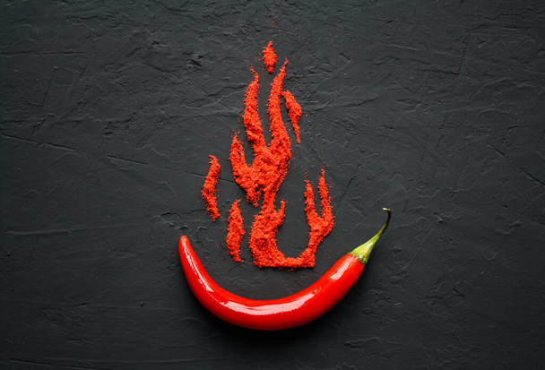 Red hot capsicum with paprika scattered in the form of flame petals - Photo, Image