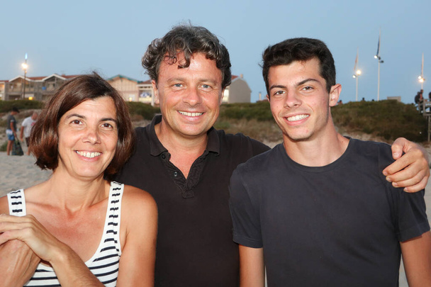 familia de tres madre padre hijo adolescente posando en vacaciones noche de vacaciones
 - Foto, Imagen