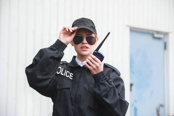Female police officer patrolling city street - Foto, imagen