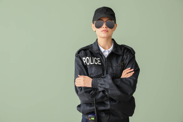 Female police officer on color background - Foto, afbeelding