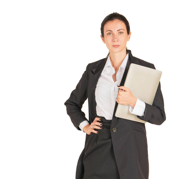 A business woman in a black suit holding on a computer notebook. Portrait on white background with studio light. - Φωτογραφία, εικόνα