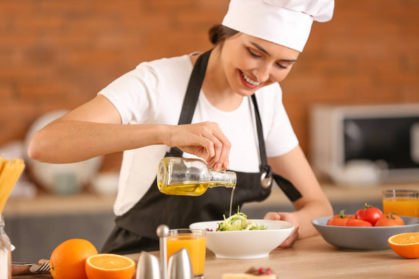 Mujer chef aderezo sabrosa ensalada en la cocina
 - Foto, Imagen