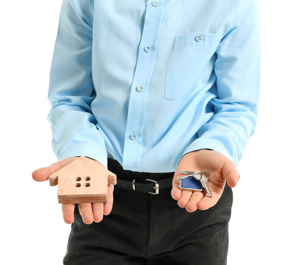 Pieni kiinteistönvälittäjä malli talon ja avain valkoisella taustalla
 - Valokuva, kuva