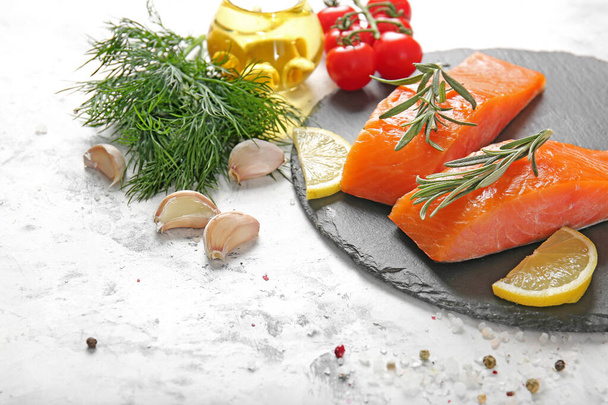 Raw salmon fillet with herbs, lemon and garlic on white background - Photo, Image