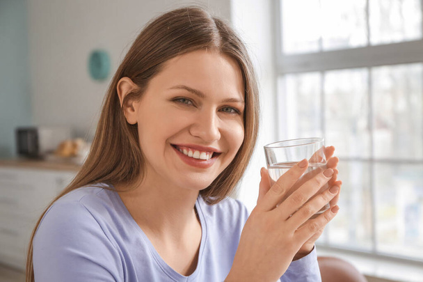 Belle jeune femme boire de l'eau à la maison - Photo, image