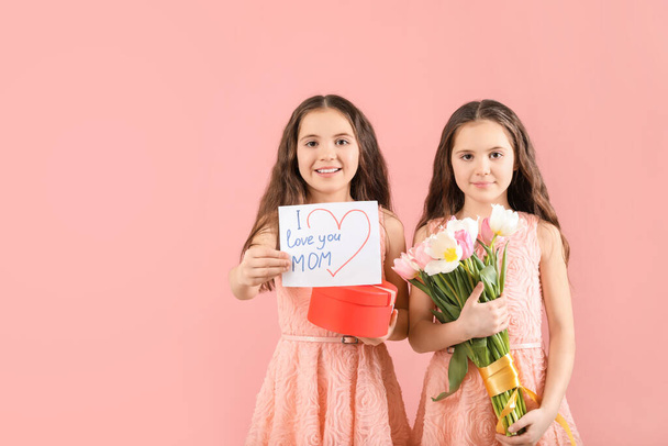 Девочки с подарками на День матери на цветном фоне
 - Фото, изображение