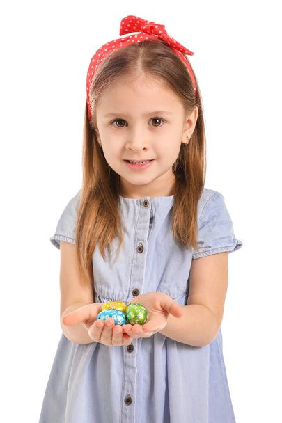 Cute little girl with sweet chocolate eggs on white background - Fotoğraf, Görsel