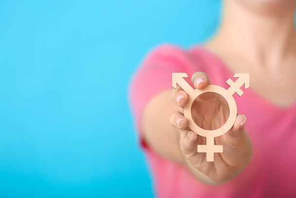 Женщина с символом трансгендера на цветном фоне
 - Фото, изображение