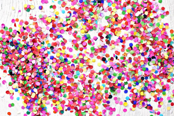 On a light wooden surface there are different coloured confetti - Photo, Image