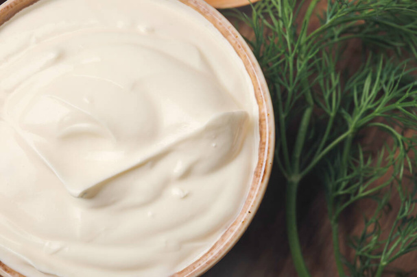 Bowl of tasty sour cream on table, closeup - 写真・画像