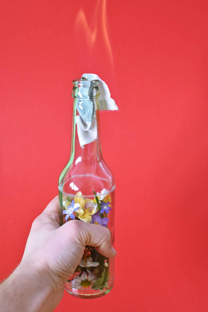Коктейль Молотова, наповнений барвистими квітами - любляча стійкість, зображена над палаючою поверхнею, наповненою квітами - абстрактна еко-боротьба
 - Фото, зображення