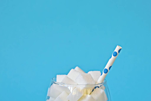Ein Glas voller Zuckerwürfel als Symbol einer ungesunden Ernährung und ungesunde Lebensmittel voller Zucker - Konzept zur Überzuckerung der Bevölkerung - Foto, Bild