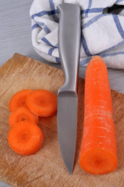 Zanahoria y cuchillo en la tabla de cortar de cerca
  - Foto, imagen