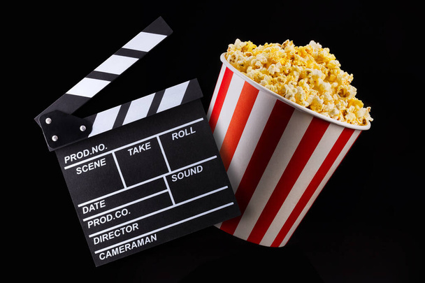 Paperi raidallinen ämpäri popcorn eristetty mustalla pohjalla
 - Valokuva, kuva