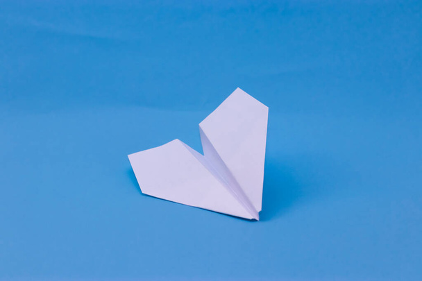 Flat lay of white paper plane and blank paper on pastel blue color background. - Fotografie, Obrázek