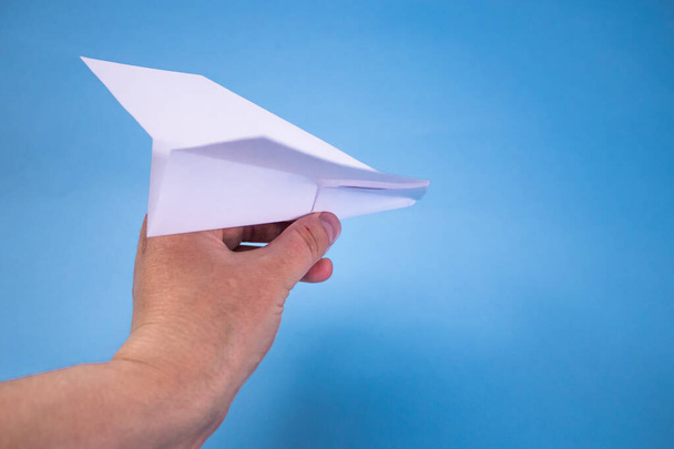 Flat lay of white paper plane and blank paper on pastel blue color background. - Photo, Image