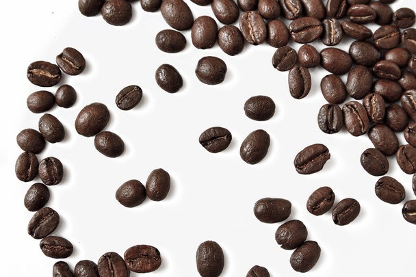 grains de café renversés sur une assiette blanche, grains torréfiés de qualité
. - Photo, image