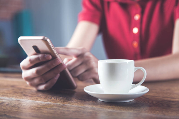 woman hand smart phone with cup of coffee on desk - Fotoğraf, Görsel