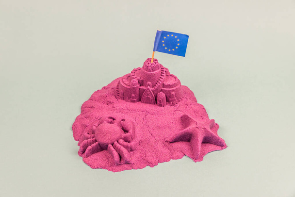 Ένα νησί με ευρωπαϊκή σημαία σε ένα κάστρο άμμου - Φωτογραφία, εικόνα