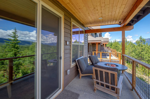 Csodálatos erkély terasz kandallóval és erdővel és hegyekre néző kilátással. Az álom valóra válik otthon külseje. Új amerikai építészet. Kényelmes és gyönyörű otthoni részletek. - Fotó, kép