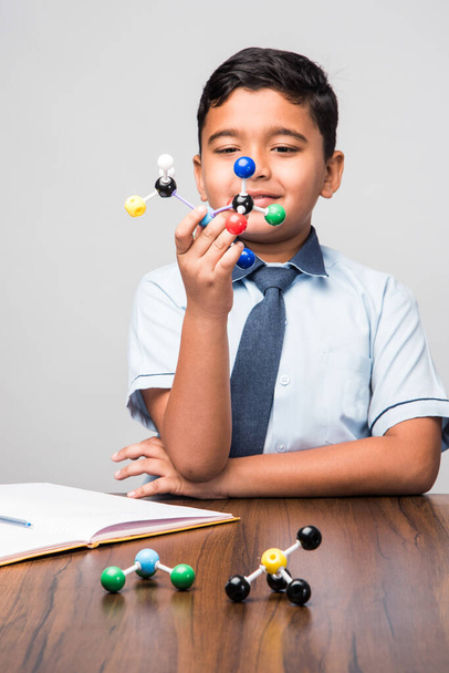 Indian school kid or science student Using Molecular Model Kit for study physics, selektywne skupienie - Zdjęcie, obraz