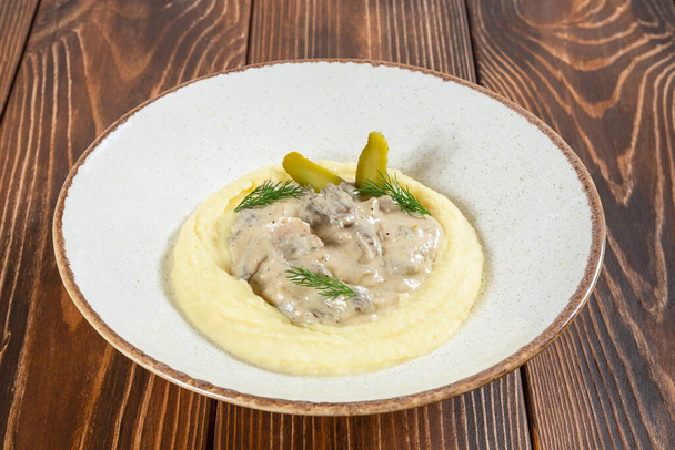 Plate of beef stroganoff with mashed potatos on wooden table - Photo, Image