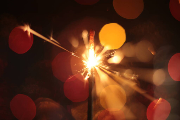 festive burning sparkler macro photo multicolor bokeh garlands - Photo, Image
