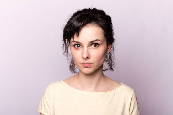 young girl in a yellow t-shirt on a gray background - Фото, зображення