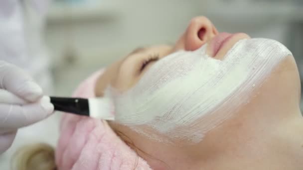 kozmetológus alkalmazza a krémet a bőr egy nő arcát. Kozmetológia, fiatalítás. - Felvétel, videó