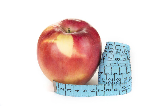 Fita métrica em torno de uma maçã. Conceito de dieta e perda de peso
 - Foto, Imagem