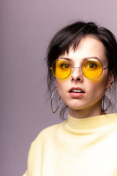 beautiful girl in yellow glasses and a yellow sweater - Valokuva, kuva