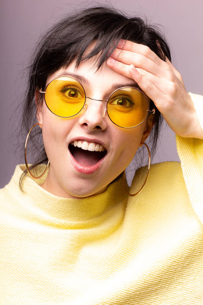gyönyörű lány sárga szemüvegben és sárga pulóverben - Fotó, kép