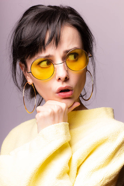 beautiful girl in yellow glasses and a yellow sweater - Valokuva, kuva