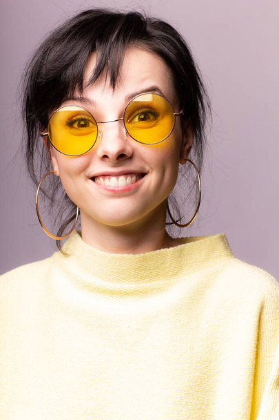 beautiful girl in yellow glasses and a yellow sweater - 写真・画像