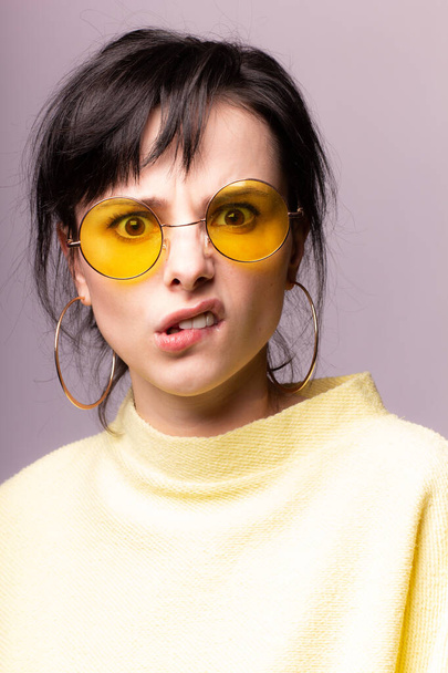 beautiful girl in yellow glasses and a yellow sweater - Foto, Bild