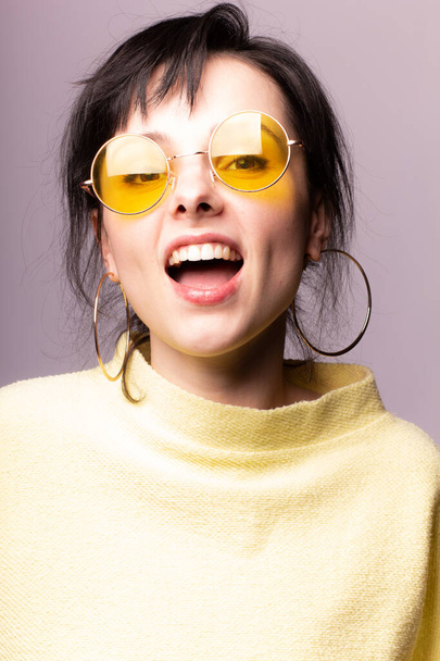 beautiful girl in yellow glasses and a yellow sweater - Zdjęcie, obraz