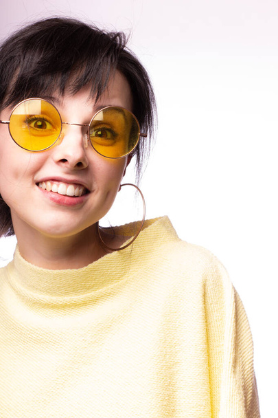 beautiful girl in yellow glasses and a yellow sweater - Foto, Imagen