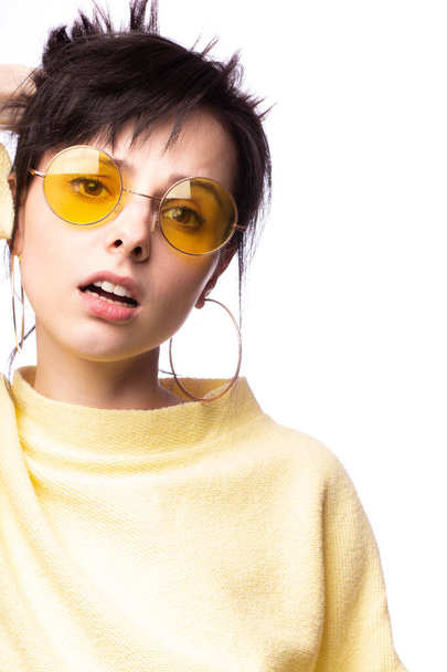 beautiful girl in yellow glasses and a yellow sweater - Foto, afbeelding