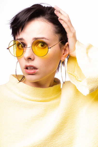 beautiful girl in yellow glasses and a yellow sweater - Foto, Bild