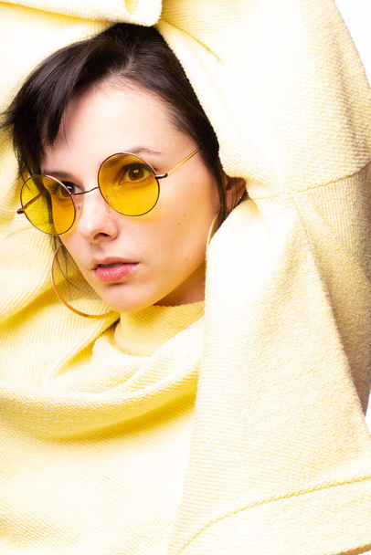 beautiful girl in yellow glasses and a yellow sweater - Fotoğraf, Görsel